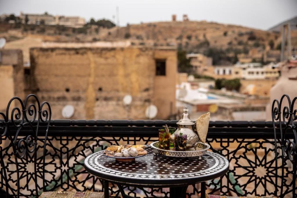 a table with a plate of food on a balcony at Dar al haja rahma in Fez