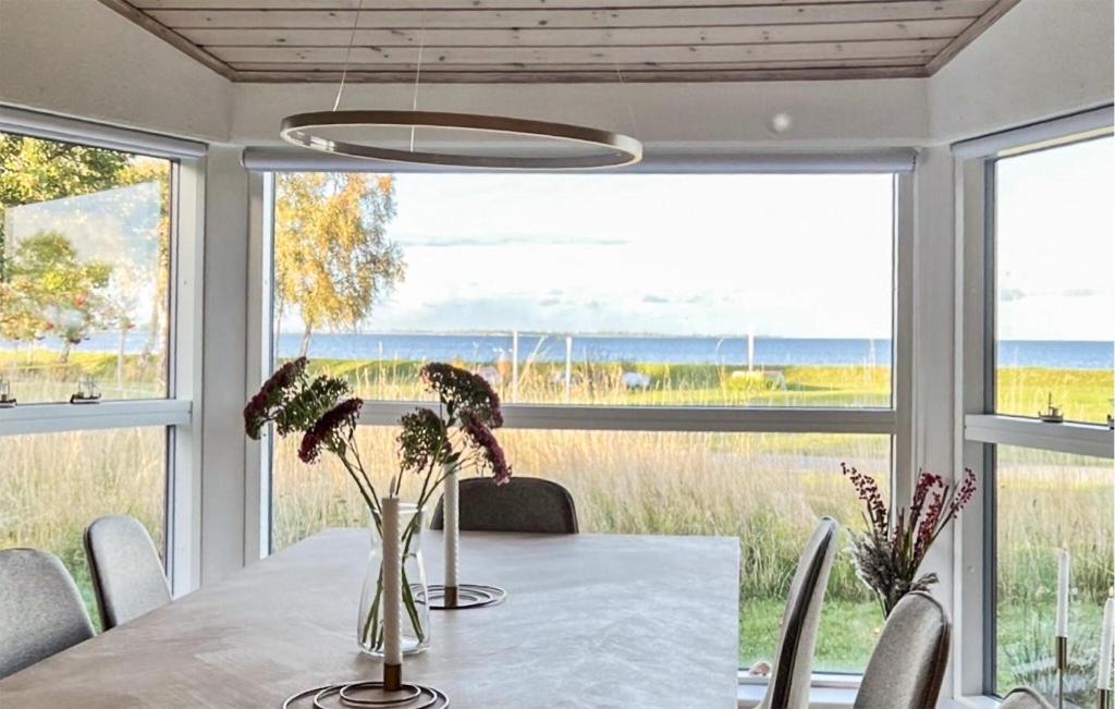 a dining room with a table and views of the ocean at 2 Bedroom Cozy Home In Askø in Askø