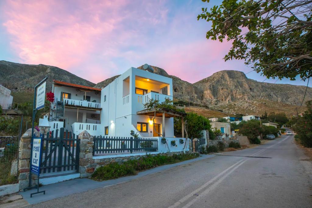 a house on a street with mountains in the background at Themelina Studios in Emborios