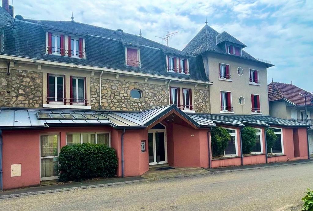 a large building with red trim on a street at Beauséjour in Calvinet