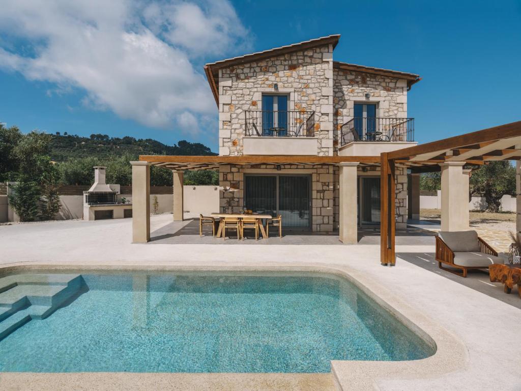 an external view of a villa with a swimming pool at Bedrock beachside villa with private pool in Vasilikos