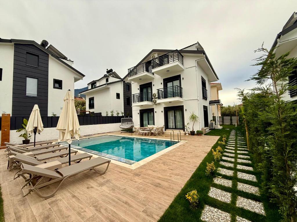 a house with a swimming pool in the yard at As Villas Villa Asil in Fethiye