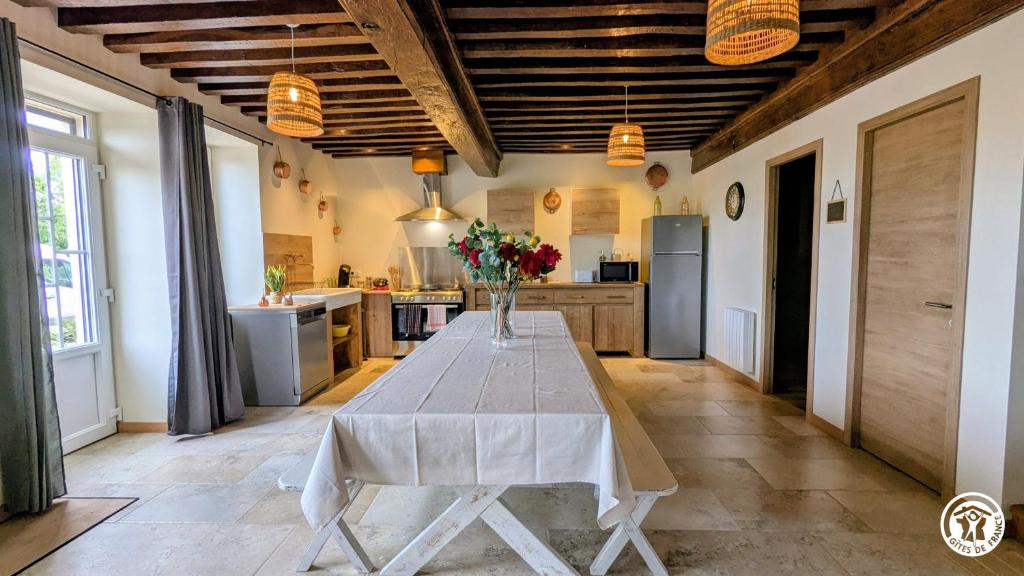 a kitchen with a table with a vase of flowers on it at Clos de Vellerot in Saint-Pierre-en-Vaux