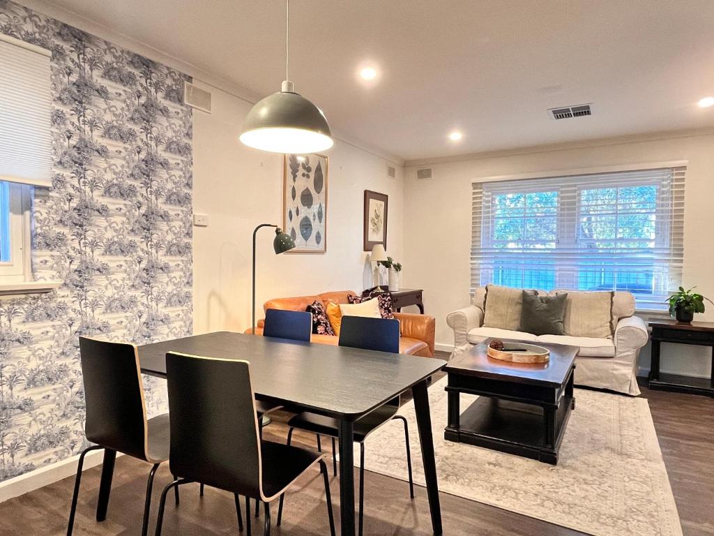 a living room with a table and a couch at Cozy Lovely flat 3km to CBD in Glenunga