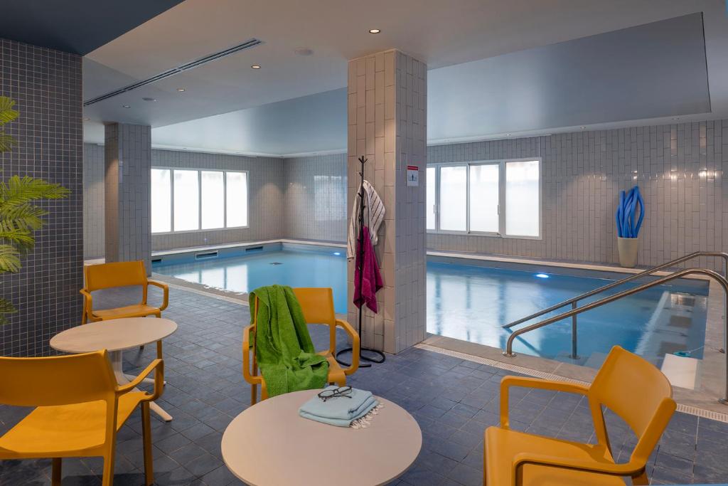 a pool with tables and chairs next to a tablesktop at DOMITYS - L'Edito in Amiens