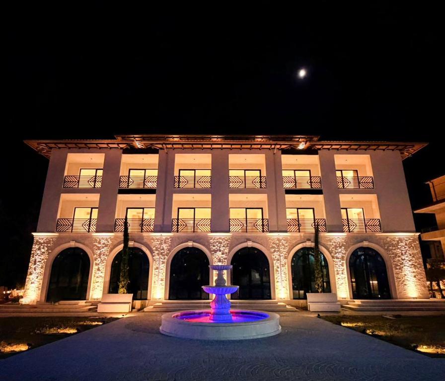 a large building with a blue fountain in front of it at CITADEL Heritage Hotel Berat in Berat