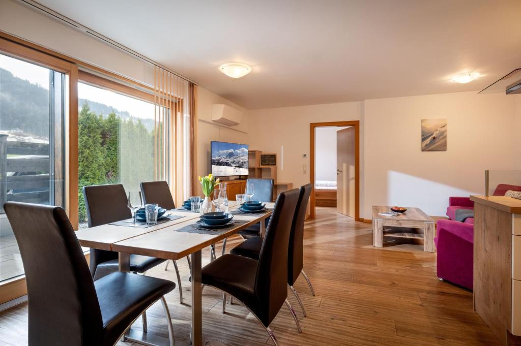a dining room and living room with a table and chairs at Sonnplatzl Appartement Westendorf in Westendorf