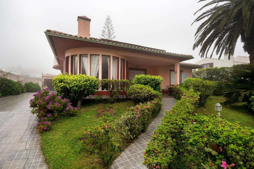a house with bushes and flowers in front of it at Casa Carmen in Cabouco