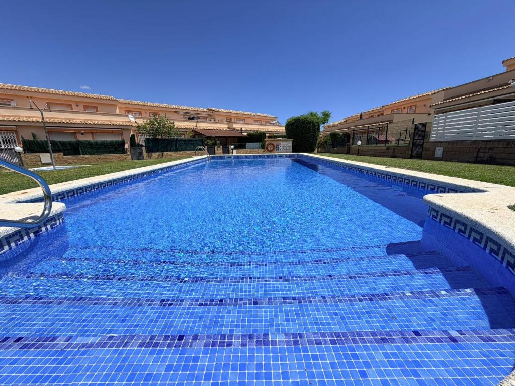 a large blue swimming pool in a building at Casa Chiqui in Miami Platja