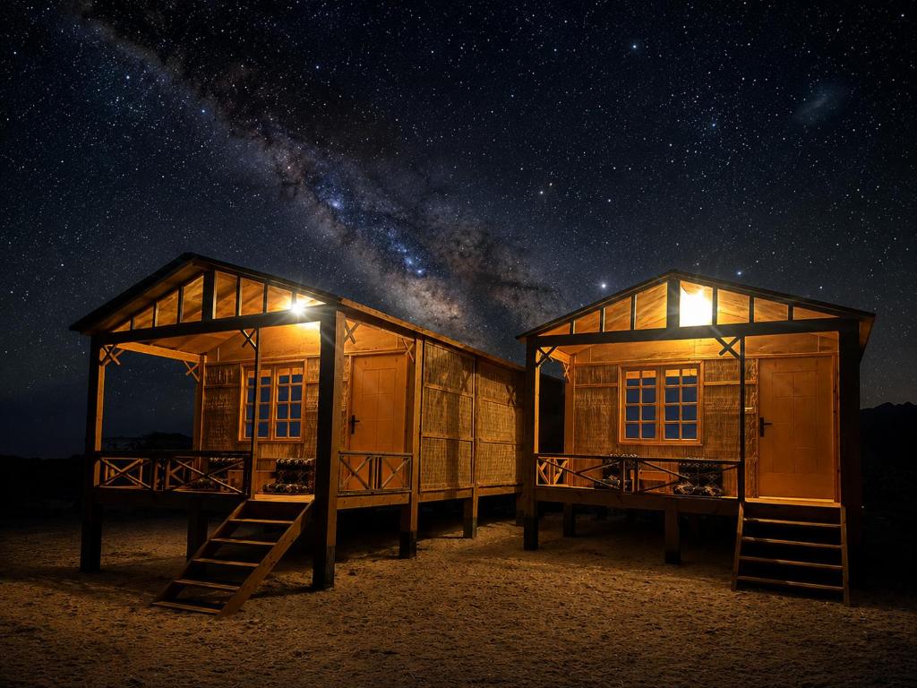 ein paar Hütten im Sand bei Nacht in der Unterkunft Falak in Taba