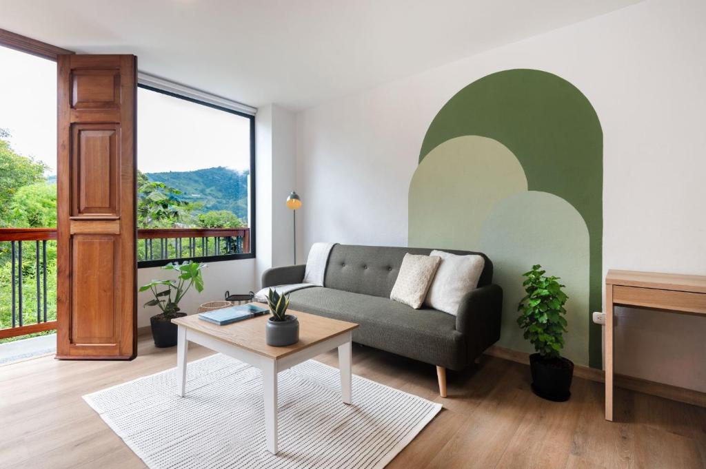 a living room with a couch and a table at Amaru Suites Salento - Apartamentos con Jacuzzi y Vistas al Bosque in Salento