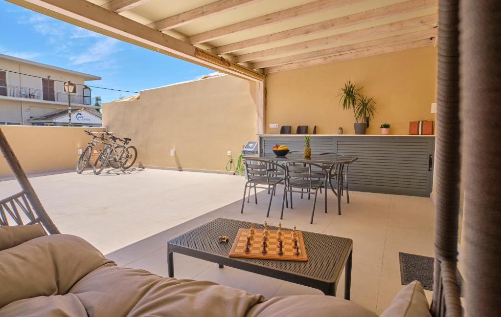 a living room with a couch and a chessboard on a patio at Irene Luxury Suite Roda in Roda
