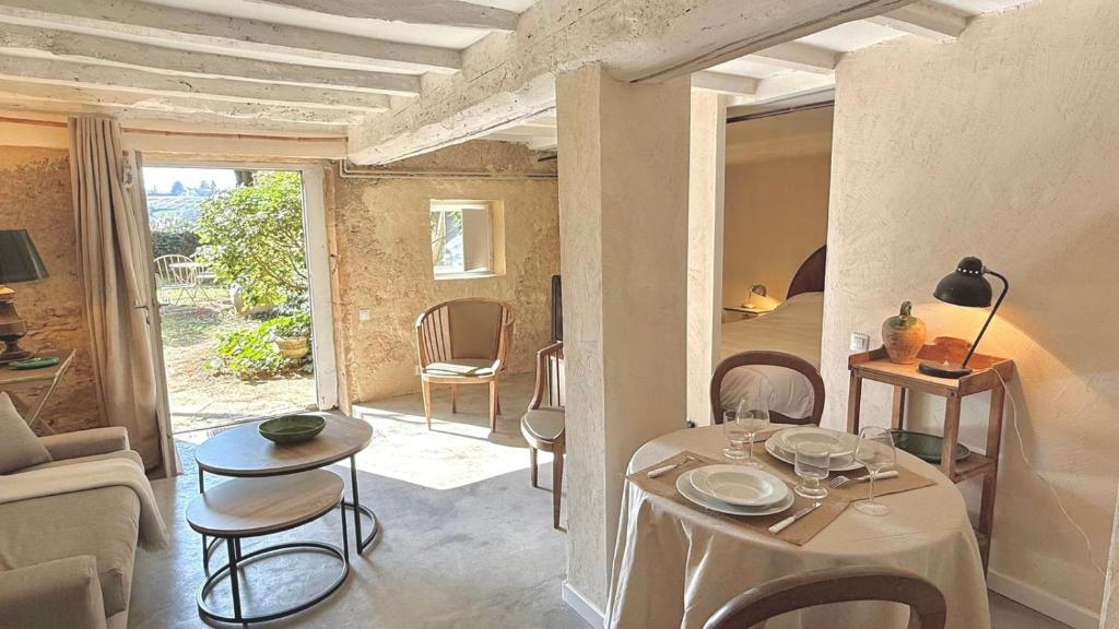 a living room with a table and chairs and a couch at Le Refuge in Denicé