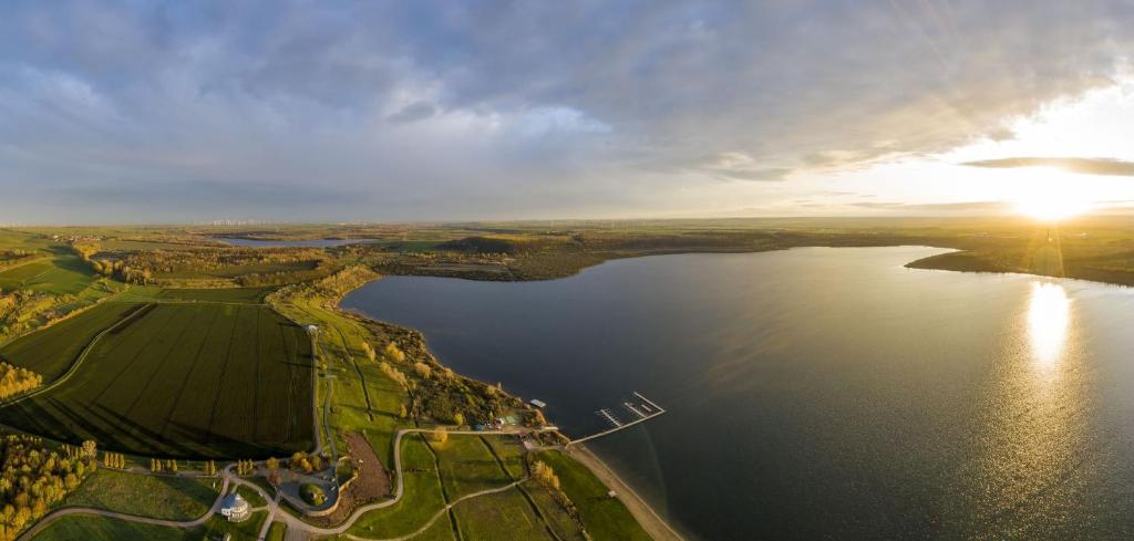 an aerial view of a large lake with the sun setting at Ferienhaus B2 Concordiasee in Friedrichsaue