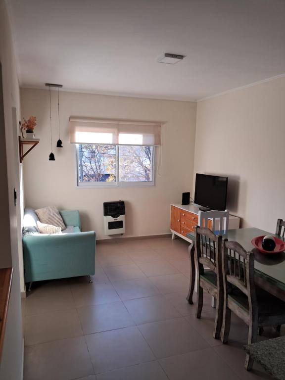 a living room with a table and a couch at Departamento juana con cochera in Rafaela