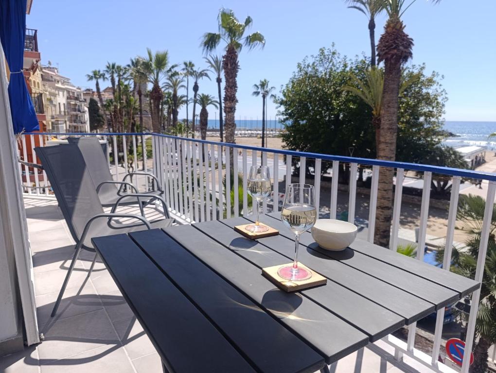 a table on a balcony with a view of the beach at Seafront Sitges in Sitges