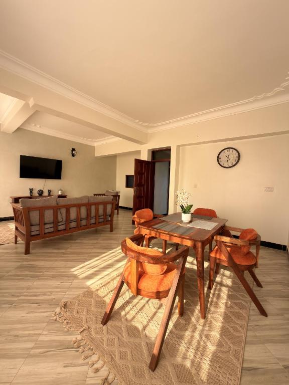 a living room with a table and chairs and a couch at Express Living & Wellness in Jinja