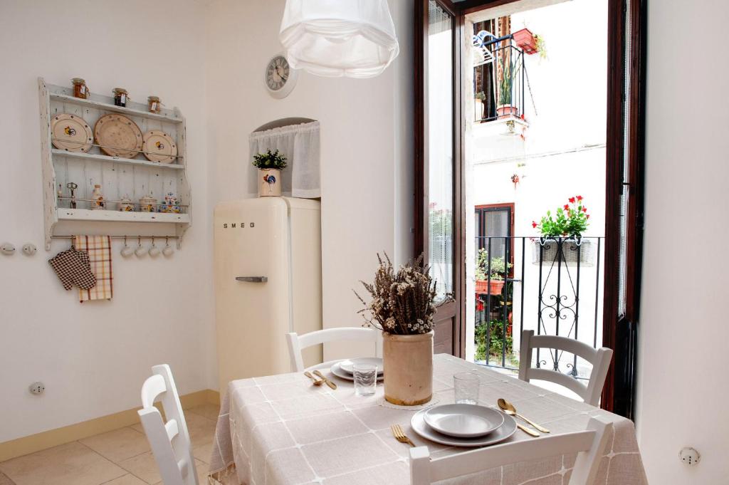 a dining room with a white table and a window at Antica casa Scesciola in Rutigliano
