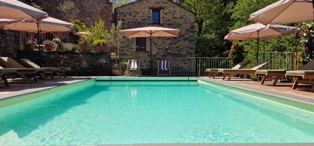 a large swimming pool with chairs and umbrellas at Casetta in Ortiporio