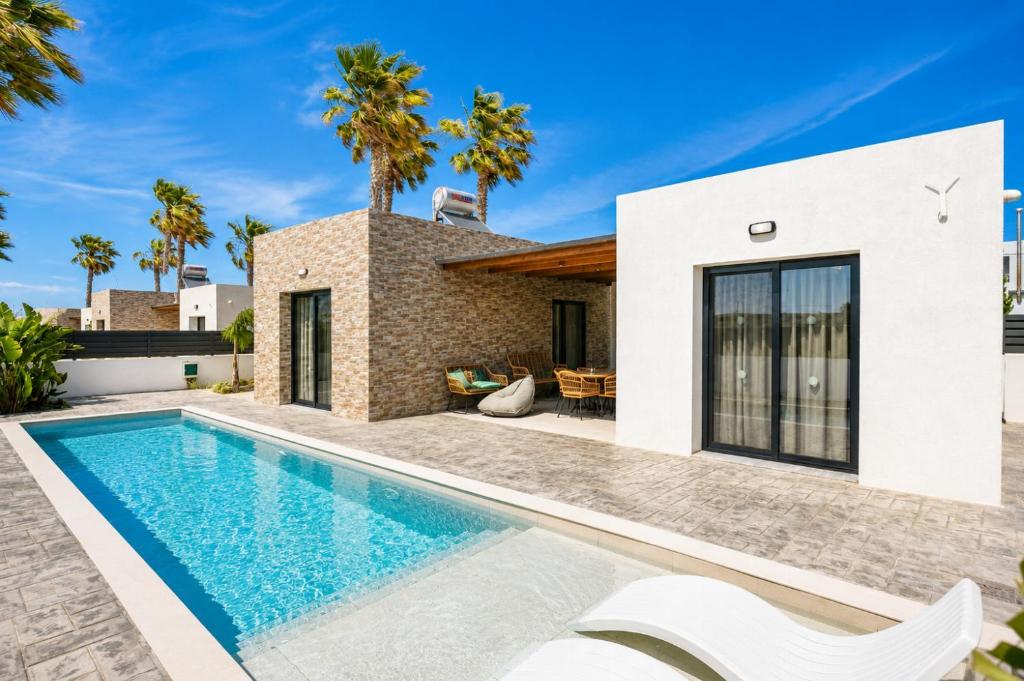 a villa with a swimming pool and a house at Villa Salty Sun 7 in Kremasti