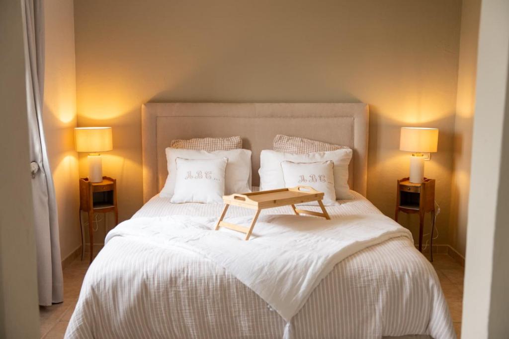 a bedroom with a bed with a table on it at Le Castelas - Hébergement complet in Aurons