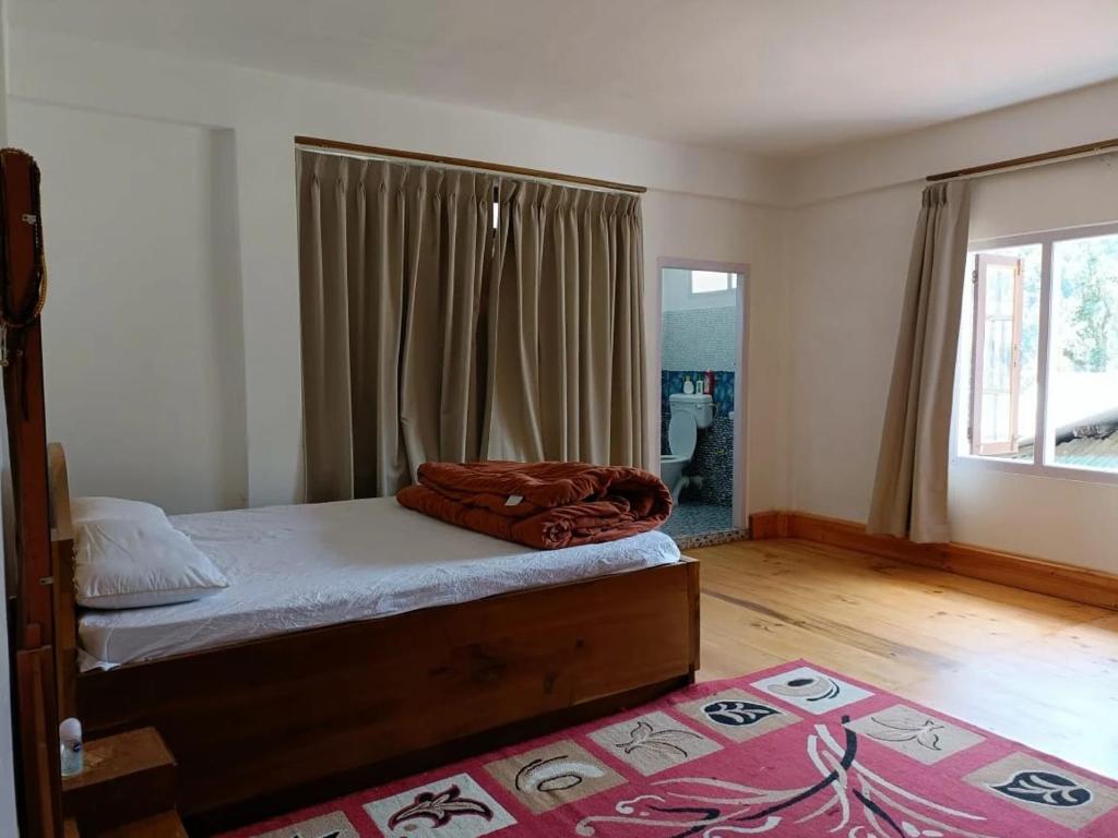 a bedroom with a bed and a large window at The Blooming Tulip in Shergaon