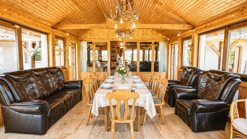 a dining room with a table and leather chairs at Szabó Tanya Nyim in Nyim