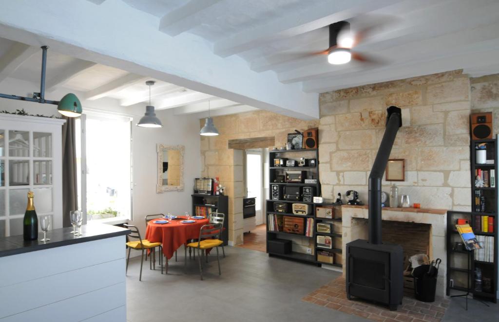 a kitchen and dining room with a table and a fireplace at Le Petit Musée in Loches