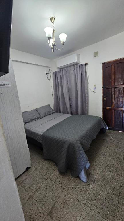 a bedroom with a bed with a gray comforter at Apartamento Angélica in Resistencia
