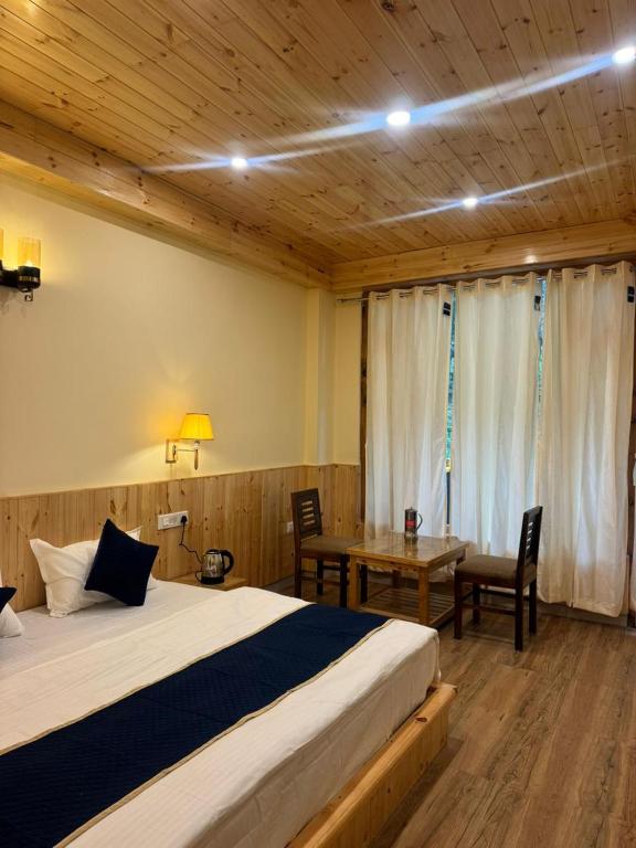 a bedroom with a bed and a table and a desk at The Zoland in Jibhi