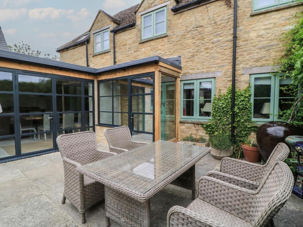 a patio with a table and chairs in front of a house at Fairview Cottage in Burford