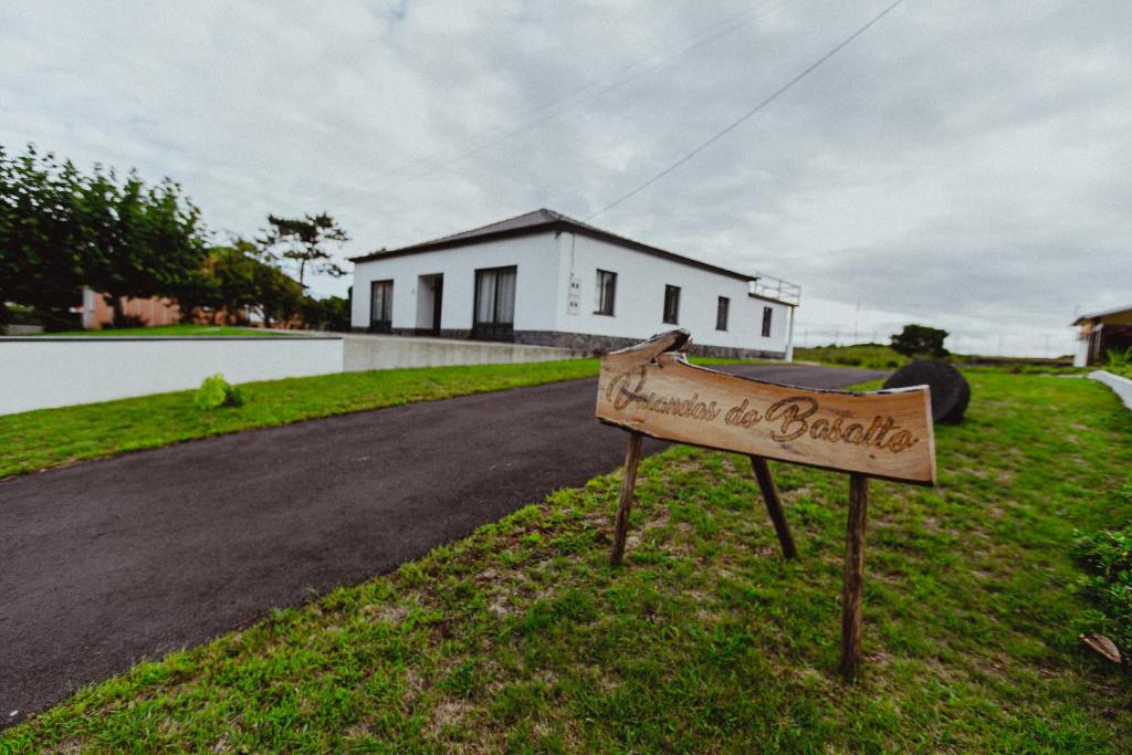 a sign in the grass in front of a house at Varandas do Basalto in Queimada