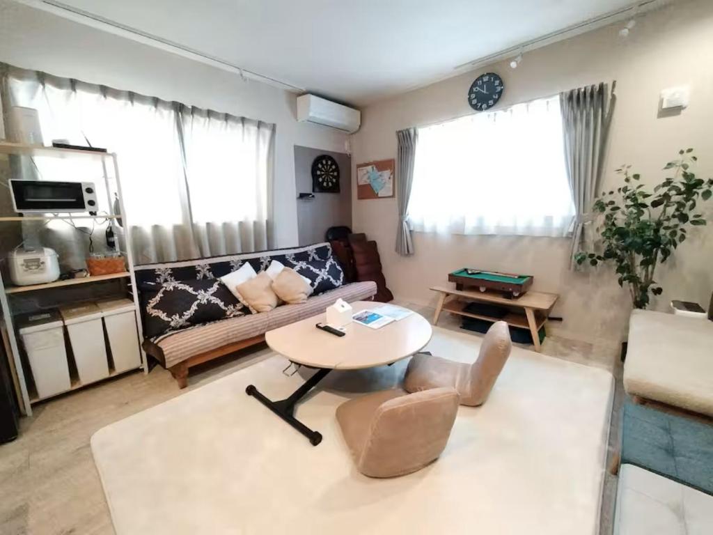 a living room with a couch and a table at Hachi Kamakura KOIWA in Tokyo