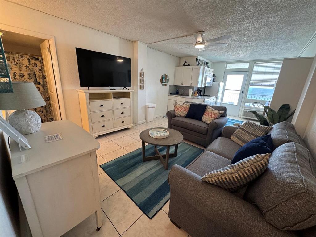 a living room with a couch and a tv at Direct ocean front view 1 bedroom 2 Pools in Daytona Beach