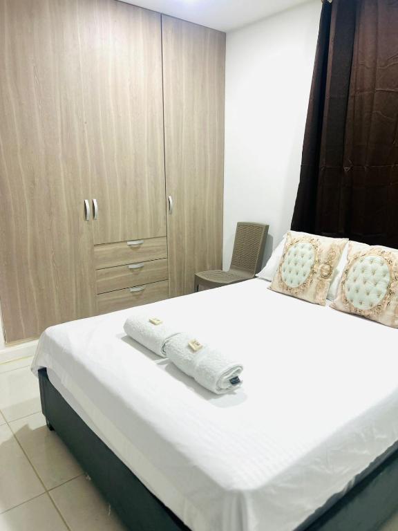 a bedroom with a white bed with towels on it at Hotel Galicia in Montería
