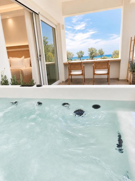 a bath tub with a view of the ocean at DelMar Suites Syros in Finikas