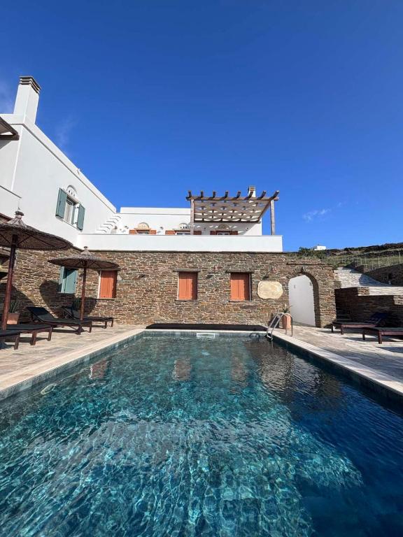 a swimming pool in front of a house at Imarkellis Tinos Boutique Villas in Panormos