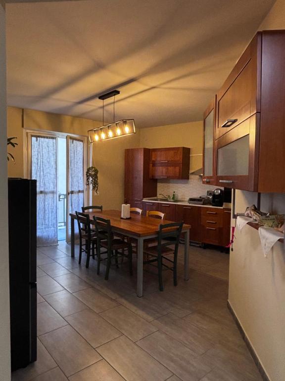 a kitchen with a table and chairs and a refrigerator at Le colline in corso Bra in Alba