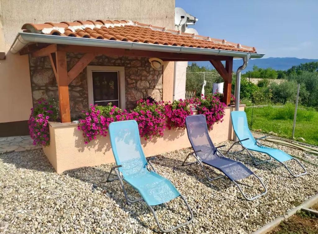 a group of chairs sitting in front of a flower box at Apartman Lidija in Risika
