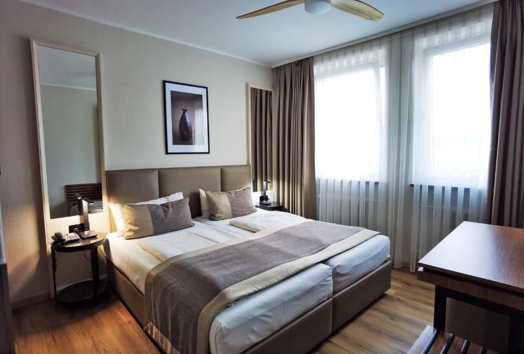 a hotel room with a large bed and windows at Hotel Italia in Munich