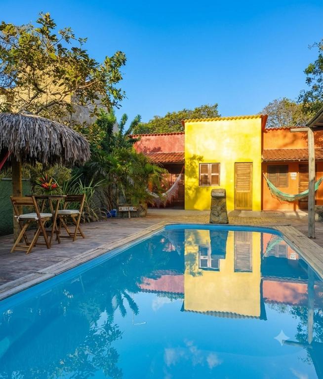 a villa with a swimming pool and a house at Vila Pescador Fortim in Fortim