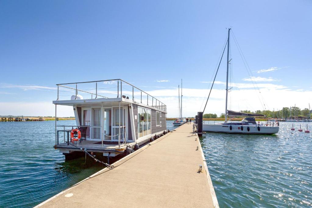 a boat is docked at a dock in the water at Hausboot Lydia in Gager in Gager