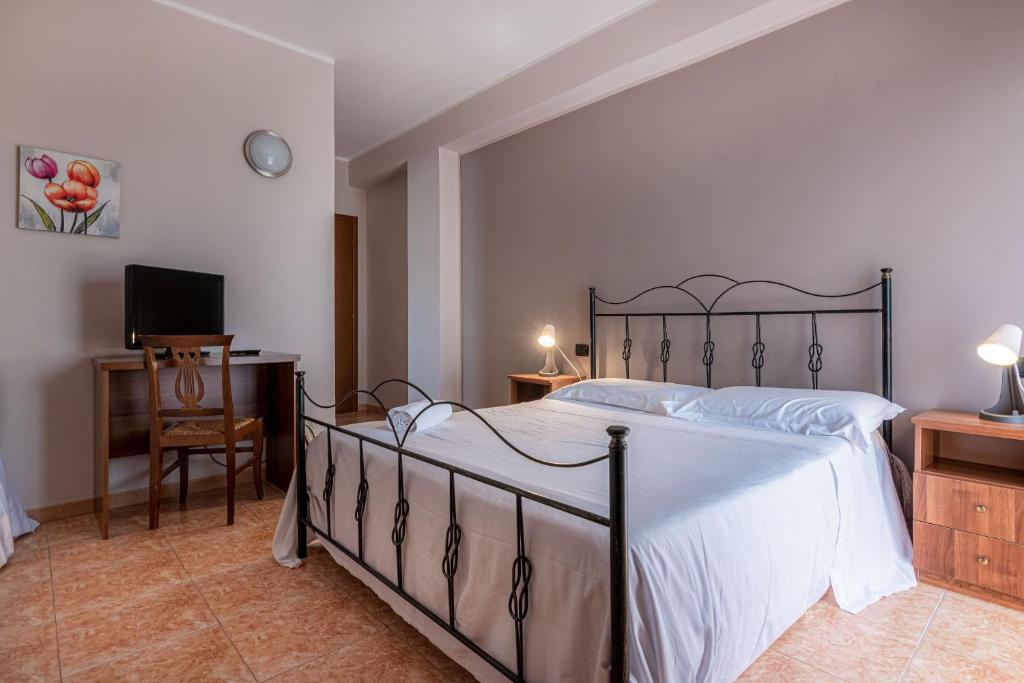 a bedroom with a bed and a desk and a television at Hotel Ristorante L'Orizzonte in Le Castella