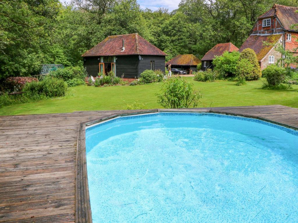 a large swimming pool in a yard with a house at The Granary in Petworth