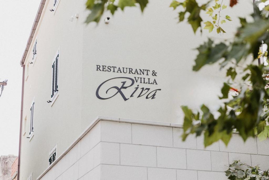 a sign on the side of a white building at Villa Riva in Makarska