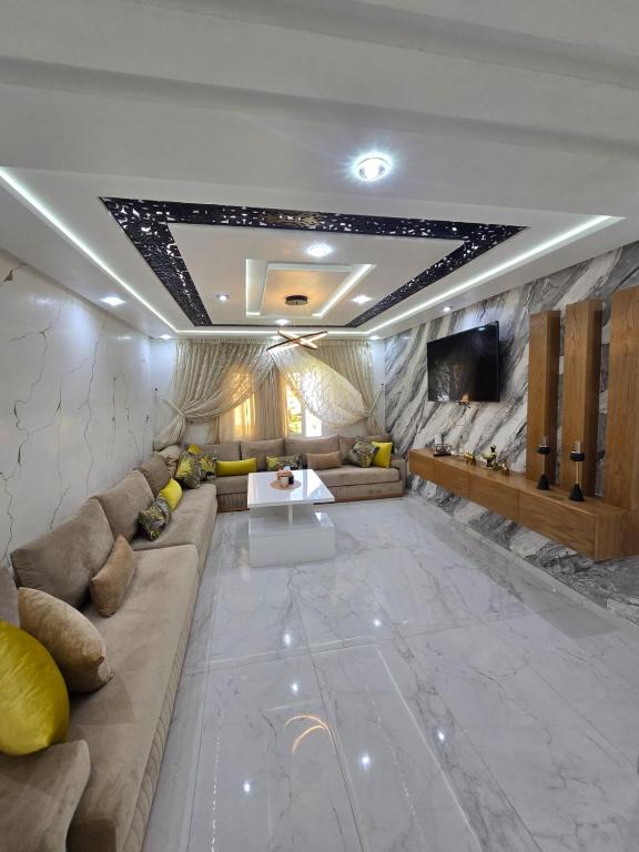 a large living room with a couch and a tv at pacotanjawi achakar in Tangier