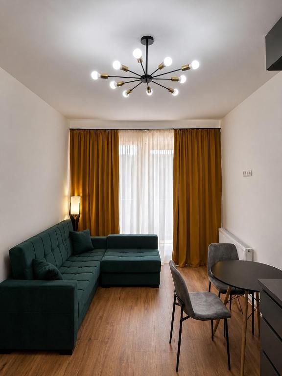 a living room with a green couch and a table at Thela Apartment in Telavi