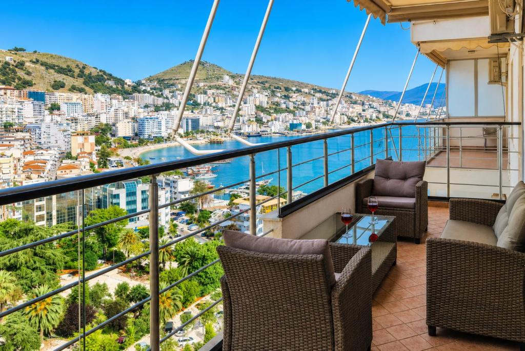 a balcony with chairs and a view of the city at Panorama Sky Apartment in Sarandë
