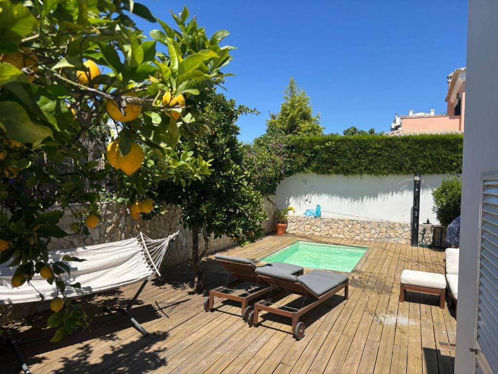 a deck with a hammock and a swimming pool at Villa Alvoria in Alvor