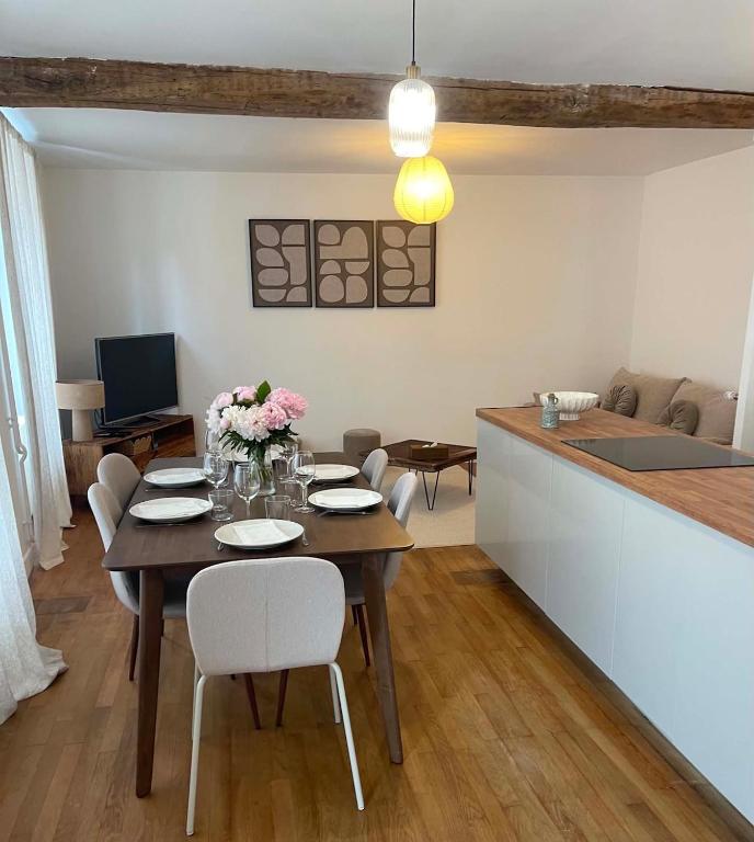 a dining room with a table and a kitchen at Maison Oria in Souvigny